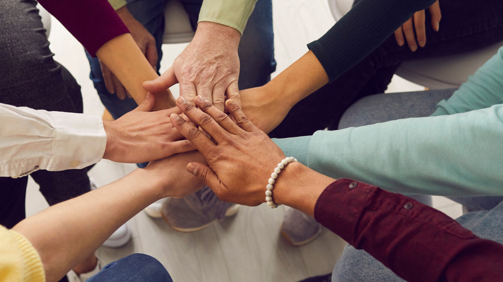 Seven hands on top of each other to represent a team