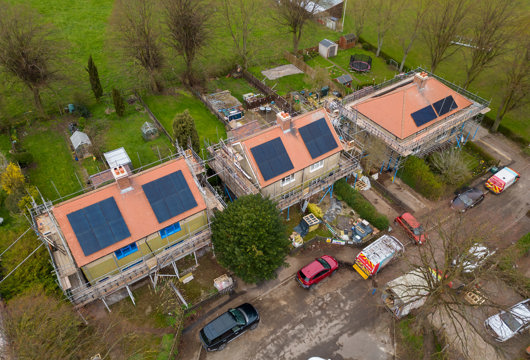 An aerial photograph of some new houses being built with solar panels on the roof. 