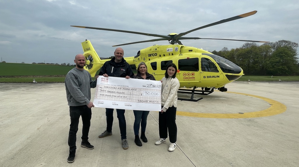 Four Yorkshire Housing Colleagues posing with the £30,000 cheque for Yorkshire Air Ambulance