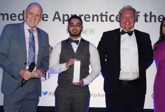 Picture of apprenticeship winner with three others at a formal awards ceremony.