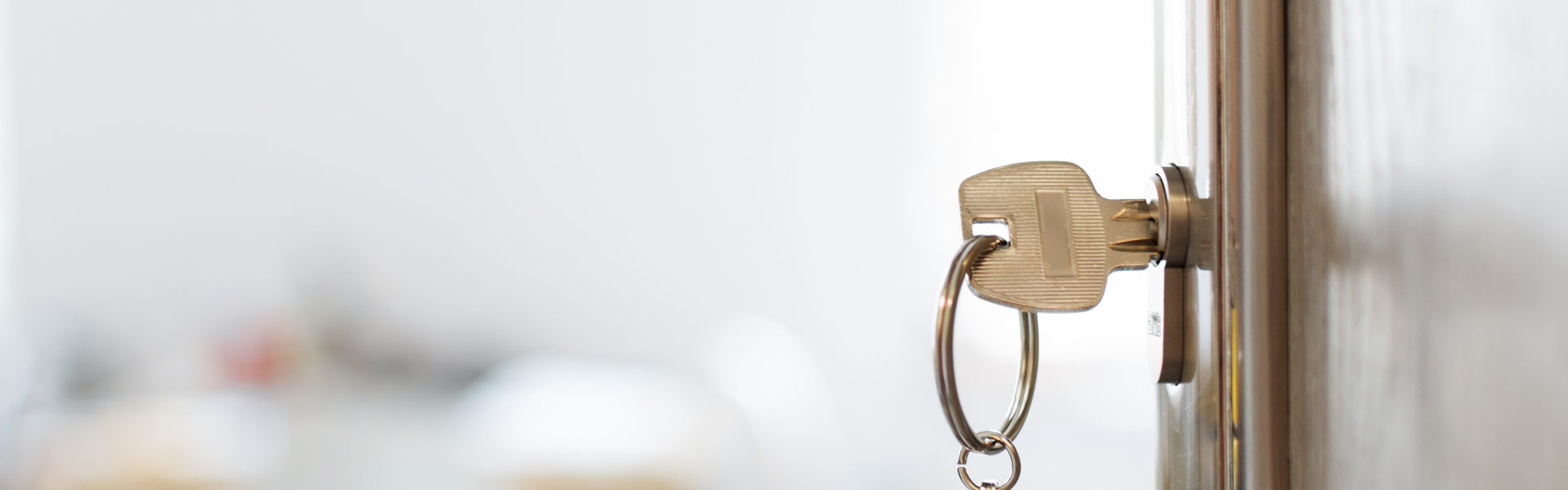 Front door open into a home with the keys hanging from the lock.
