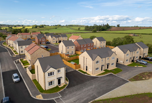 A drone image of affordable homes at the Bridgewell development in Spofforth with blue skies and countryside in the background.