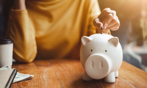 Woman putting money in a piggy bank