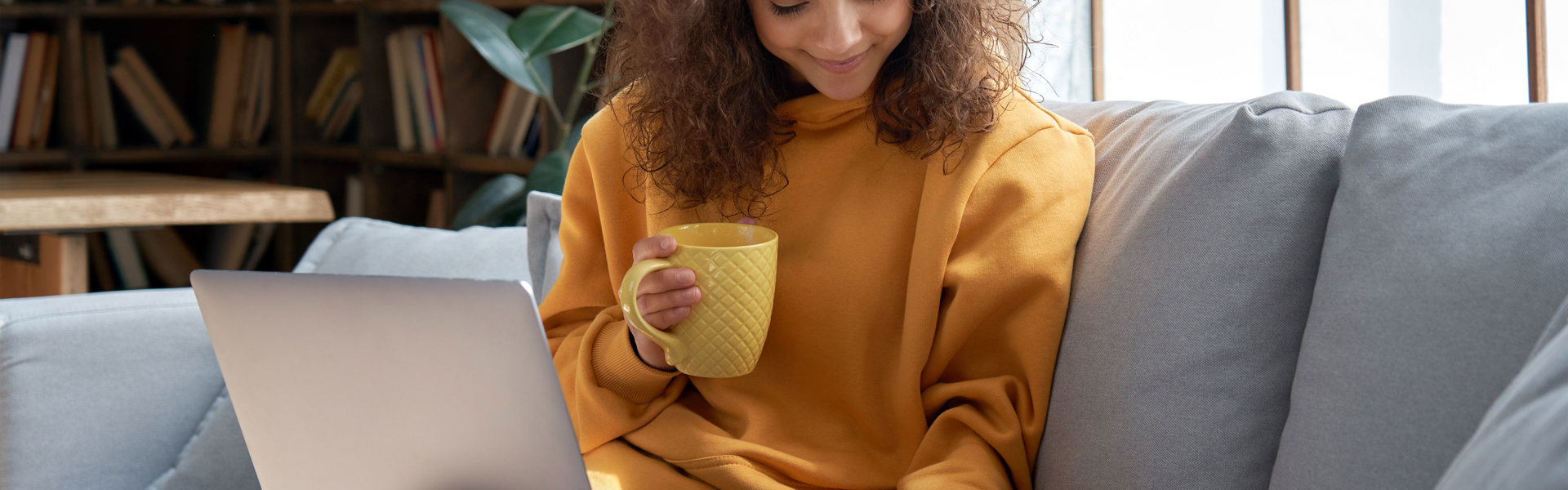 Women sitting on the sofa smiling and stroking her cat
