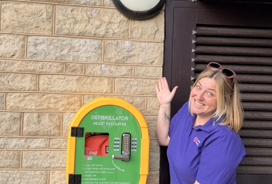 Fran standing next to one of the new defibrillators installed at a Yorkshire Housing scheme.