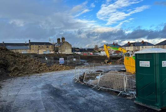 Construction site with houses in the background