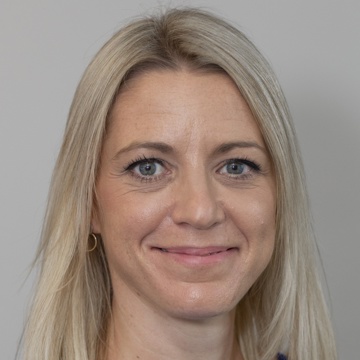A professional headshot of Nina Evison
