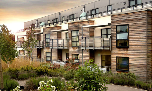 Modern flats with wood panel frontage and balconies overlooking gardens