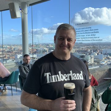 Man with pint of beer smiling at camera