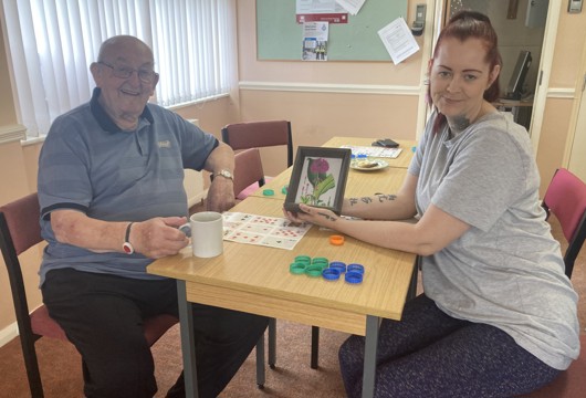 Sarah one of our volunteers with a customer who made her a piece of art