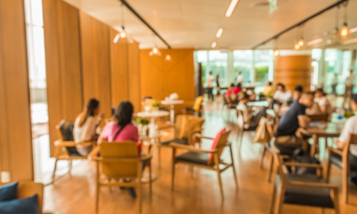 People sitting around tables in indoor community space