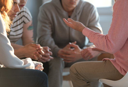A close-up photo of a group of people talking during a sit-down discussion.