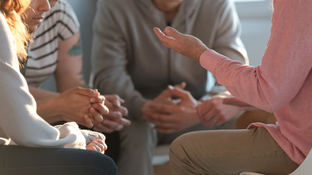A close-up photo of a group of people talking during a sit-down discussion.