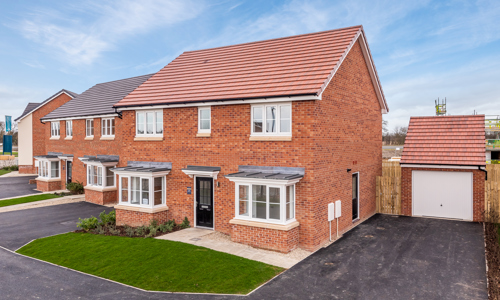 Red brick detached house with a small lawn at the front and a driveway to the side