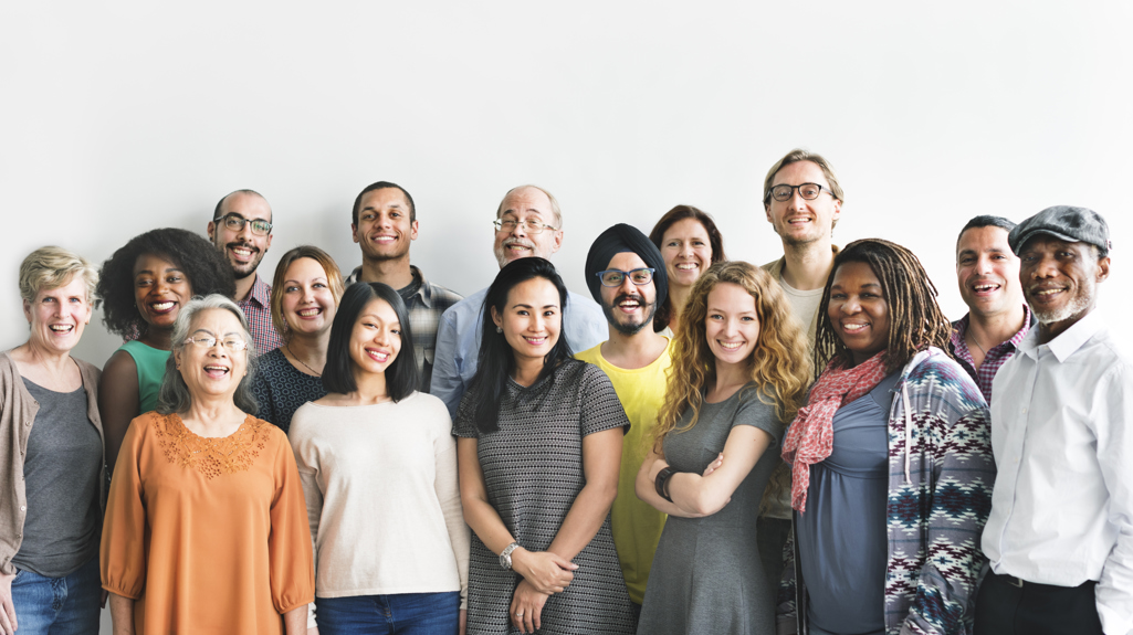 Large Group Of People Standing Together And Smiling At Camera