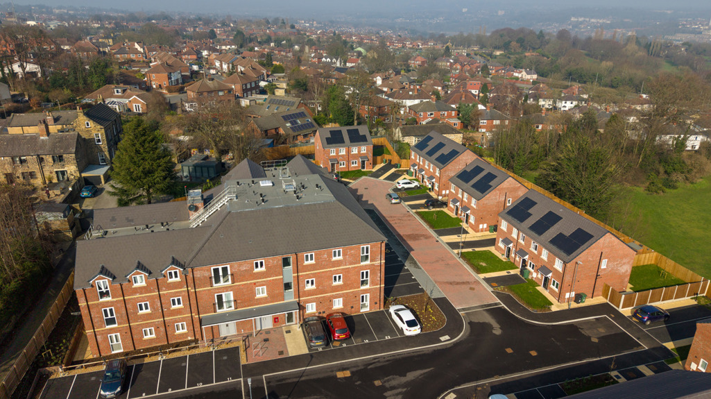 Aerial view of the main apartment building and surrounding new homes at St Andrews Grange.