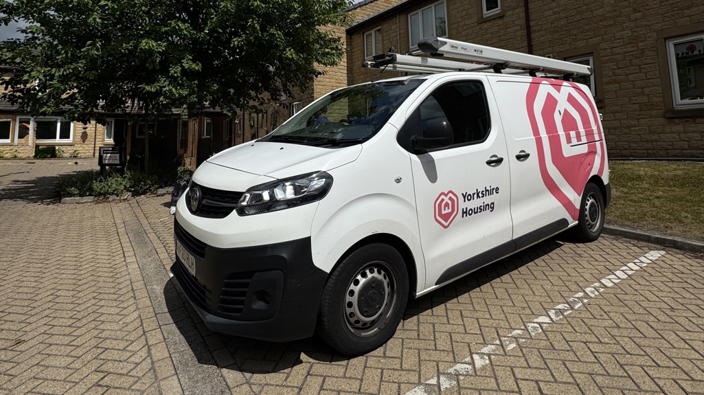 A white van with Yorkshire Housing branding on the side in front of one of our schemes