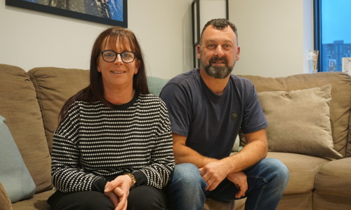 Yorkshire Housing customers Liz and Paul sat on the sofa at their new home at the Climate Innovation District in Leeds.