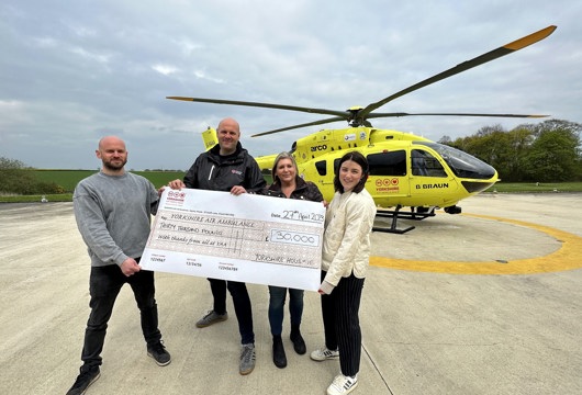 Four yorkshire housing colleagues holding a giant cheque for Yorkshire Air Ambulance, a close up! 