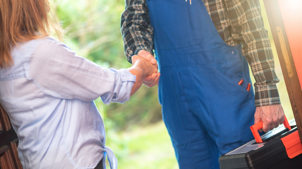 Woman shaking hand with repair man