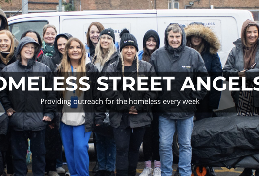 Group of volunteers standing outdoors in front of a white van during cold weather, wearing coats and hats. Overlaid text reads ‘Homeless Street Angels – Providing outreach for the homeless every week.’