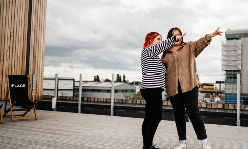 People on the rooftop of Yorkshire Housing's hub, The Place, pointing into the distance. 