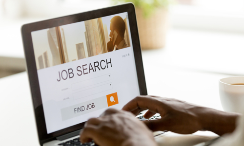 Hands typing on a keyboard, applying for a job