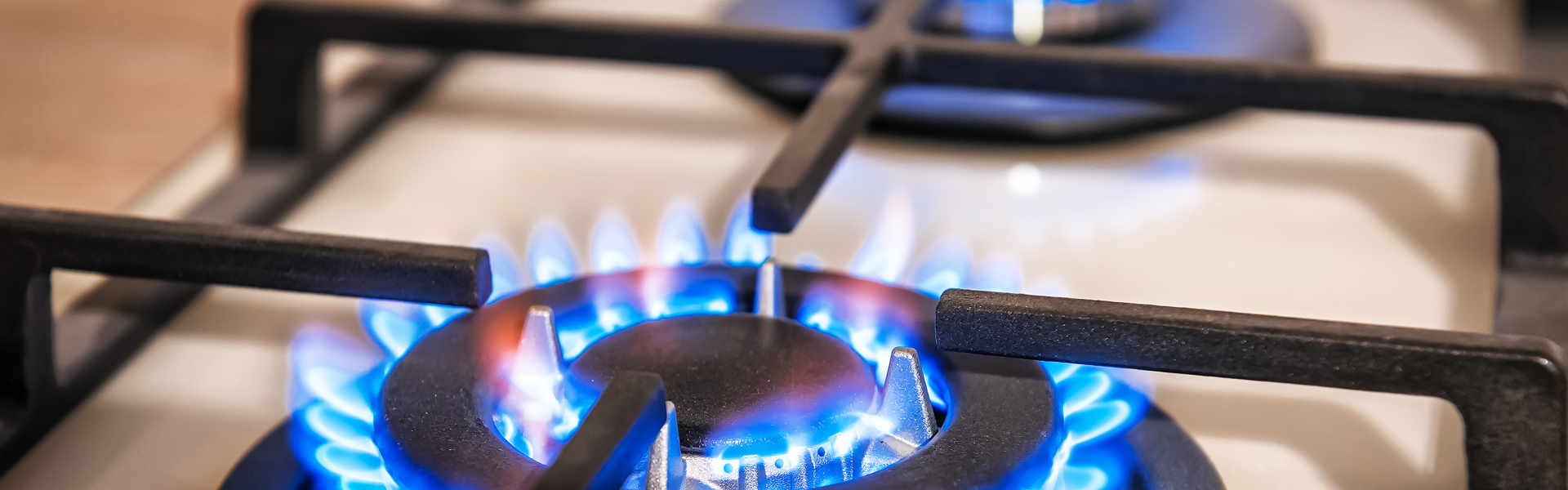 Gas hob with two rings, both have a blue flame. 