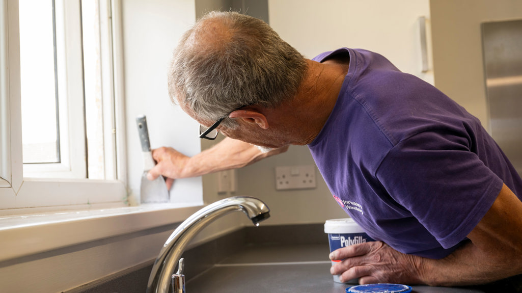 Yorkshire Housing repairs operative doing some work on a window 