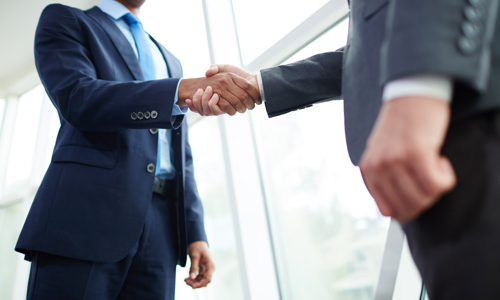 Two men in suits shaking hands