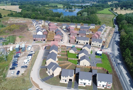 Houses being built on a development with a lake in the background