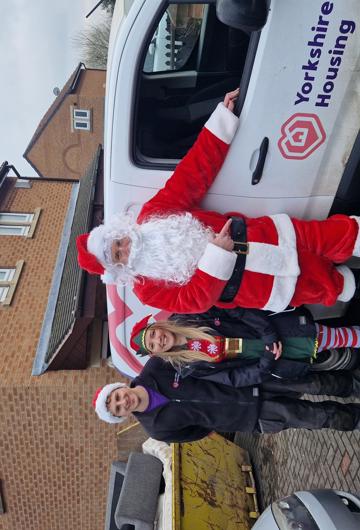 Colleagues standing in front of a Yorkshire Housing van dressed as Santa and a Christmas elf