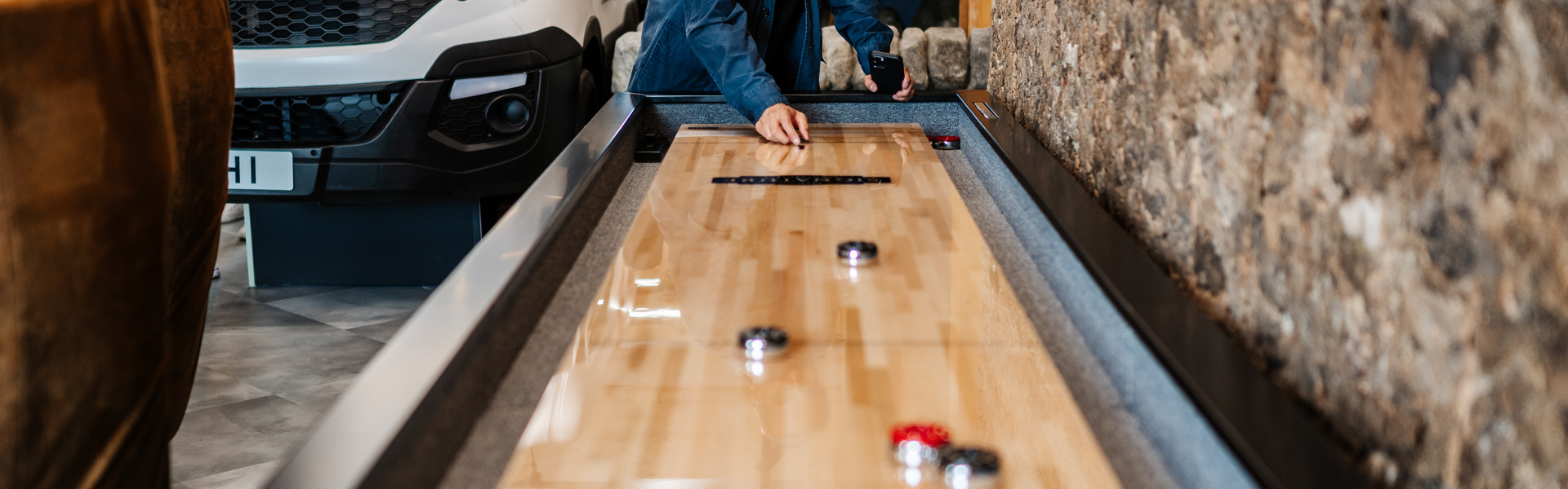 Man playing shuffleboard at The Place