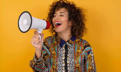 Young happy woman using megaphone