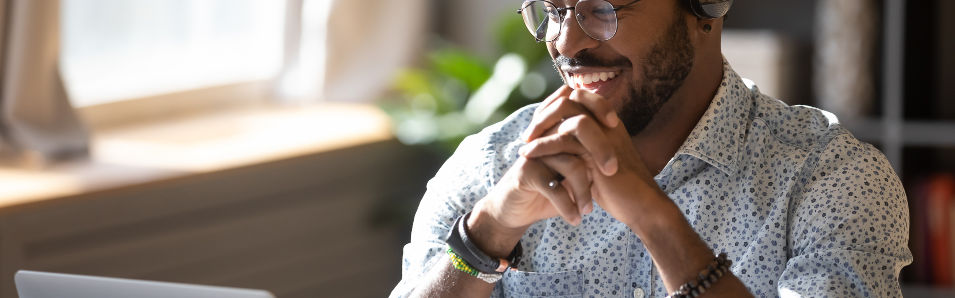 Man working on his laptop wearing a headset.